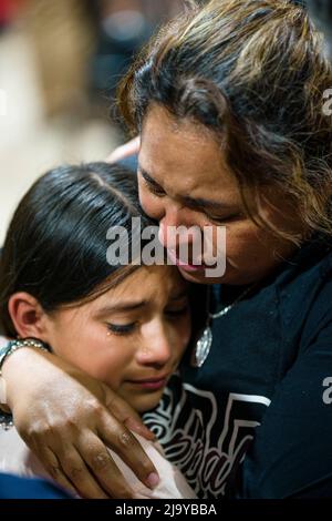 Uvalde, Texas, USA. 25.. Mai 2022. Eine Lehrerin der vierten Klasse an der Robb Elementary School in Uvalde, Texas, umarmt ihre Schülerin bei der Mahnwache für die Opfer der Massenschießerei an ihrer Schule, bei der 19 Schüler, 2 Erwachsene und der Schütze getötet wurden. Die Lehrerin sagte, dass ihr Klassenzimmer direkt neben dem Ort sei, an dem sich der Schütze verbarrikadierte, und sie sagte ihren Schülern, sie solle beten, nachdem sie Zuflucht genommen hatte. (Bild: © Jintak Han/ZUMA Press Wire) Stockfoto