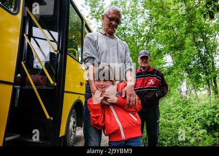 Soledar, Ukraine. 24.. Mai 2022. Menschen, die evakuiert werden sollen, stehen an dem Bus, der sie nach Dnipro bringt. Soledar ist eine Stadt der Region Donetsk, die von russischer Artillerie gehämmert wird, da sie sich entlang der entscheidenden Straße befindet, die aus dem belagerten Severodonetsk führt. (Foto von Rick Mave/SOPA Images/Sipa USA) Quelle: SIPA USA/Alamy Live News Stockfoto