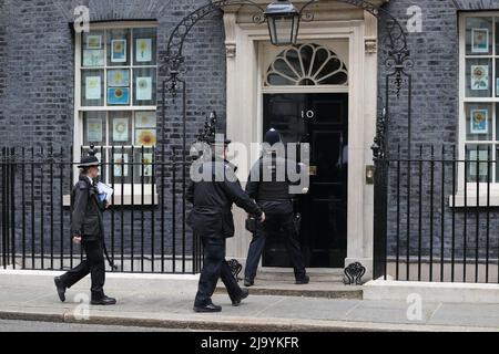 London, Großbritannien. 25.. Mai 2022. Städtische Polizeibeamte betreten die Downing Street Nr. 10 am Tag der Veröffentlichung des Berichts von Se Grey. Stockfoto