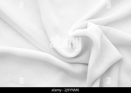 Gewellter weißer Chiffon-Stoff als Textur oder Hintergrund, gedrehtes weiches transparentes Tuch Stockfoto
