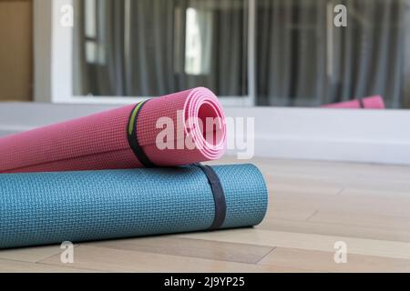 Yogamatten auf dem Boden im Innenraum des Klassengymnastiks für Yoga, Fitness und Sport. Gesunder Lebensstil, Meditationskonzept. Hochwertige Fotos Stockfoto