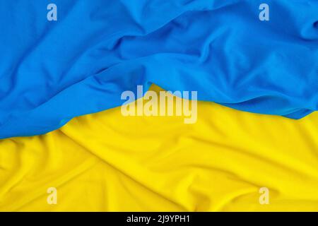 Gelbes und blaues Nylon- oder Polyestergewebe als Textur oder Hintergrund. Draufsicht auf gelb-blaues Tuch Stockfoto