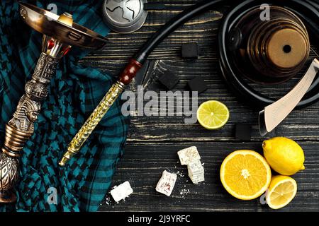 Blick von oben auf die Shisha mit orange Obst auf einem hölzernen Hintergrund Stockfoto