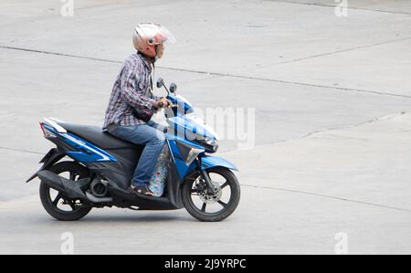 SAMUT PRAKAN, THAILAND, APR 02 2022, Ein Mann mit Helm fährt ein Motorrad Stockfoto