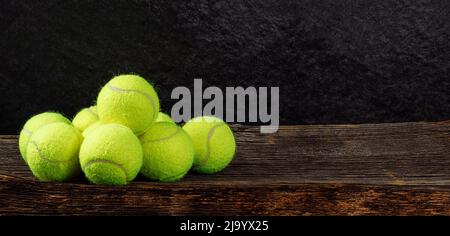 Tennisbälle auf Holzhintergrund, Sportkonzept, Platz für Text Stockfoto
