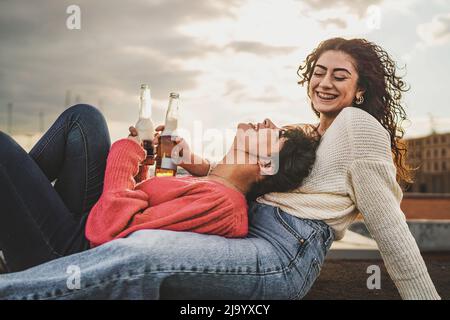 Ein paar junge Mädchen entspannen trinken mexikanische Biere am Hafen, auf der niedrigen Wand liegen - Lifestyle-Konzept der jungen Frauen unbeschwert Zeit t verbringen Stockfoto