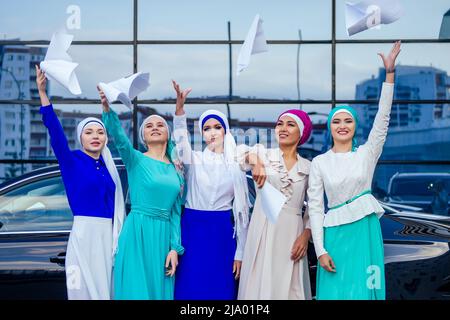 Gruppe von fünf starke schöne und junge muslimische Geschäftsfrauen Mode aussehen stilvolle lange Kleid und der Turban auf dem Kopf halten Papier, Auto und Stockfoto