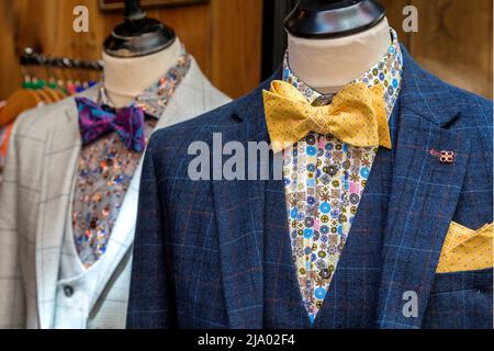 Sehr schicke Herrenanzüge zum Verkauf in einem Geschäft in der High Street. Konzept der Modeindustrie, des Einzelhandels oder der hohen Straßenausgaben. Stockfoto