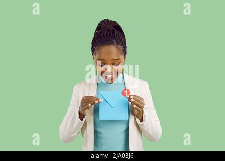 Lächelnde schwarze Frau erhält in ihrer Post eine Benachrichtigung über neue Geschäftsbotschaft Stockfoto