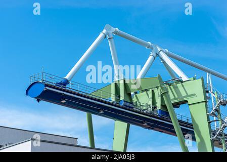 Eine massive Hafenbrücke auf Schienen, die auf dem Umladeplatz stehen, ist ein riesiges Stahltraversen sichtbar. Stockfoto