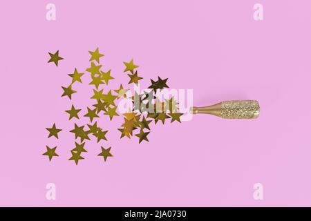 Konfetti mit goldenem Stern aus der Champagnerflasche auf rosa Hintergrund Stockfoto