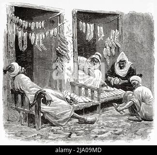 Traditionelle Hausschuhe Werkstatt. Marokkanische Babouches oder Leder Hausschuhe Shop. Souk Medina von Fez, Fes el Bali, Marokko. Nordafrika. Marokko von Edmondo de Amicis 1875. Le Tour du Monde 1879 Stockfoto