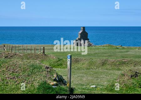 Wales Coast Path und Pilgrim's Way Schild mit den Ruinen einer Zollbeamten-Hütte im Hintergrund bei Porth Ysgaden auf der Halbinsel Llyn Stockfoto