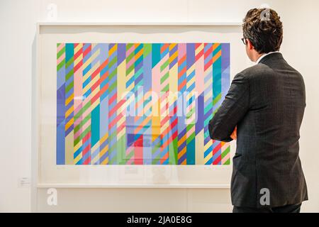 London, Großbritannien. 26.. Mai 2022. Eine Vertreterin der Galerie von Marlborough Graphics posiert mit 'June' (1992) von Bridget Riley. Die London Original Print Fair 37. wird bis zum 29.. Mai 2022 im Somerset House eröffnet - darunter Werke von Picasso, Hockney und exklusive Werke zum Jubiläum der Königin. Sie ist die am längsten laufende Druckmesse der Welt und wurde 1985 an der Royal Academy of Arts gegründet. Quelle: Imageplotter/Alamy Live News Stockfoto