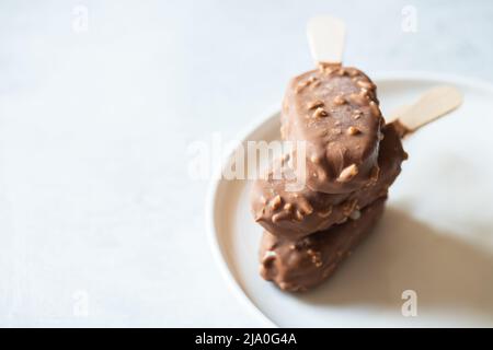 Mandelschokolade-Eis auf einem Stock. Nahaufnahme. Stockfoto