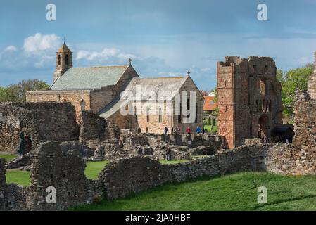 Priory Lindisfarne, Blick auf einen Teil der Ruinen des Priory Lindisfarne mit der Pfarrkirche St. Mary's innerhalb seiner Mauern, Holy Island, Northumberland Stockfoto