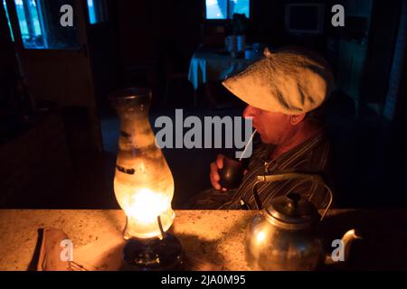 Ein Gaucho-Trinkpartner (National Argentine Drink) im Licht einer Laterne in der Estancia Santa Catalina, Pardo, Provinz Buenos Aires, Argentinien. Stockfoto