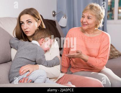 Zwei Erwachsene Frauen haben Meinungsverschiedenheiten mit dem erwachenden Kind Stockfoto