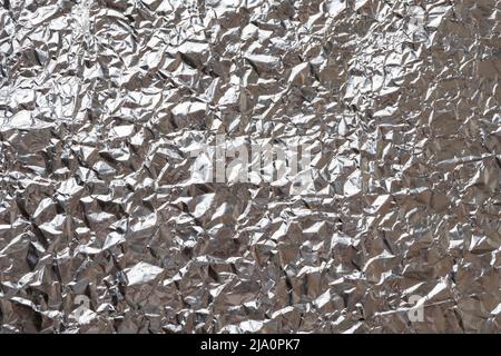 Glänzende Metall-Silberfolie Textur für Hintergrund, abstrakte zerknitterte Folie Hintergrund, metallische Folie Textur Stockfoto