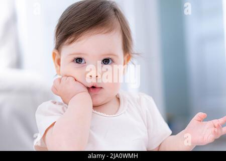 Nachdenklich niedlichen kleinen Baby-Mädchen denken verwirrt von etwas träumen oder mit einer guten Idee, lächelnd und nach oben, Phantasie. Stockfoto