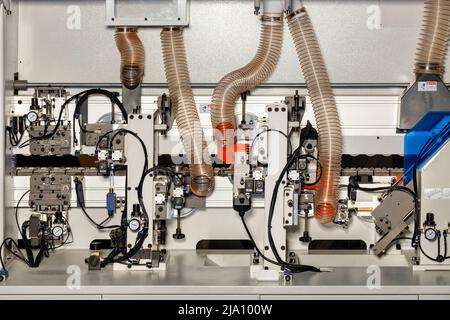 Ein Fragment der internen Kontrollmechanismen des Luftsystems in einer modernen Holzbearbeitungsmaschine mit Manometern und Kontrollmechanismen. Stockfoto