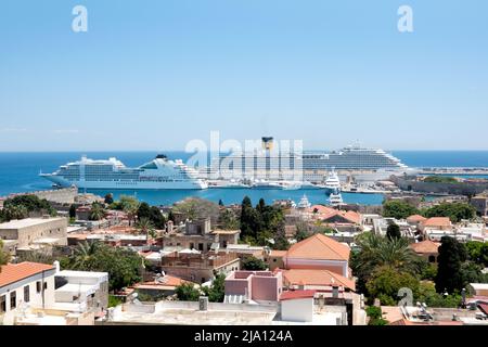 Ein Blick über Rhodos-Stadt, Rhodos in Richtung des alten Hafens und der Mandraki Marina zeigt zwei große Kreuzfahrtschiffe, die während des Besuchs der berühmten Stadt vor Anker liegen Stockfoto