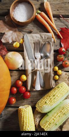 Vertikales Bild der Nähe von Besteck und halloween Herbst produzieren auf rustikalem Hintergrund Stockfoto