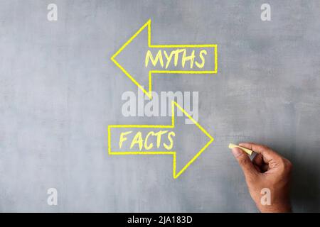 Hand zeichnen Pfeil mit Text MYTHEN und FAKTEN mit Kreide. Mythen vs Fakten Konzept. Stockfoto