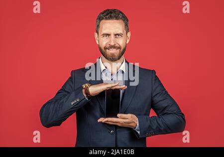 Handy App Werbung. Geschäftsmann präsentiert Produkt. Präsentation des neuen Smartphones. Stockfoto