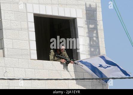 Nablus, Palästina. 12.. Mai 2022. Israelische Siedler heben israelische Flaggen auf einem Gebäude in der Mitte des Marktes in der Stadt Hawara, südlich von Nablus im Westjordanland. (Foto von Nasser Ishtayeh/SOPA Images/Sipa USA) Quelle: SIPA USA/Alamy Live News Stockfoto