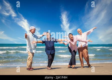 Eine Gruppe asiatischer Senioren, Männer und Frauen, die viel Spaß am Strand hatten Stockfoto