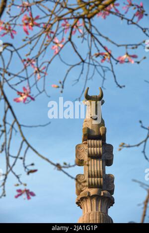 Die Skulptur „La columna del templo Persa“ zwischen Seidenfloss-Baumblumen, Palermo Gardens, Buenos Aires, Argentinien. Stockfoto