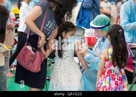 Taipeh, Taiwan. 26.. Mai 2022. Eine Mutter hält den Arm ihrer Tochter, während eine medizinische Mitarbeiterin das Kind mit dem Impfstoff Pfizer-BNT Covid-19 verabreicht. Taiwan wird voraussichtlich mit der Einführung des Impfstoffs Pfizer-BNT, Covid-19 für Kinder und Jugendliche, der Kindern im Alter von 5-11 Jahren als erste Aufnahme und Jugendlichen im Alter von 12-17 Jahren als Auffrischungsimpfung angeboten wird, beginnen. (Bild: © Jui Kun Weng/SOPA Images via ZUMA Press Wire) Stockfoto