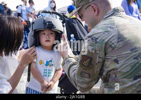 22. Mai 2022 - Yokota Air Base, Tokyo, Japan - US Air Force Capt. Chase Todd, 459. Airlift Squadron UH-1N Huey Pilot, setzt einen Helm auf ein Kind während des Japanisch-Amerikanischen Freundschaftsfestivals 2022, auf dem Yokota Air Base, Japan, 22. Mai 2022. Das zweitägige Festival bot den Besuchern die Gelegenheit, mehr über die bilaterale Partnerschaft zwischen den USA und Japan zu erfahren und gleichzeitig die Beziehungen zwischen Yokota und den lokalen Gemeinschaften zu stärken. Yokota konnte die Veranstaltung mit Unterstützung der japanischen Selbstverteidigungskräfte, der Schwesterdienste und der lokalen Gemeinschaft ausrichten. (Bild: © US Air Force/ZUMA Press WI Stockfoto