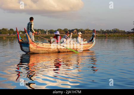 Touristen beobachten den Sonnenuntergang in U-Bein Brücke auf einem traditionellen Holzboot, Amarapura, Mandalay, Myanmar. Stockfoto