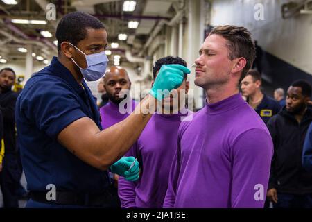 Pazifischer Ozean. 18.. Mai 2022. Hospital Corpsman 3. Klasse Darion Wilson, aus Griffin, Georgia, links, führt einen COVID-19 Test im Fahrzeugverstauungsbereich an Bord des amphibischen Angriffsträgers USS Tripoli (LHA 7) durch, 19. Mai 2022. Tripolis führt derzeit Routineoperationen in der US 7.-Flotte durch. Quelle: U.S. Navy/ZUMA Press Wire Service/ZUMAPRESS.com/Alamy Live News Stockfoto