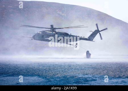 17. Mai 2022 - Skyros Island, Griechenland - Eine US Marine Corps Marine, die an die Marine Expeditionary Unit 22. angeschlossen ist und mit dem Amphibienschiff USS Arlington (LPD 24) der San Antonio-Klasse eingesetzt wird, wirft helo mit einem Kampfflugzeugs aus einem Super-Hengst-Hubschrauber CH-53E, Zugewiesen an Marine Medium Tiltrotor Squadron (VMM) 263 (rein.), während eines gemeinsamen Trainingsrazzia auf Skyros Island, Griechenland, mit hellenischen Streitkräften, 17. Mai 2022. Arlington, mit eingeschiffter 22. Marine Expeditionary Unit, nimmt an der Übung Alexander der große 2022 unter dem Kommando und der Kontrolle von Tas Teil Stockfoto