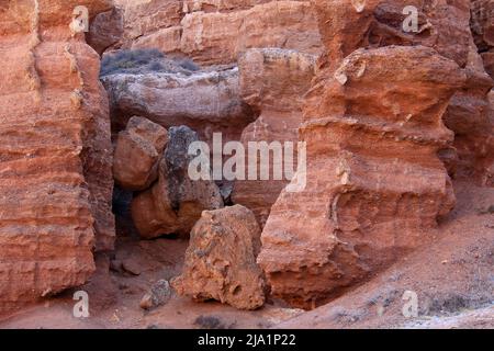 Rote sandig-lehmige riesige Steine in der Charyn-Schlucht aus nächster Nähe Stockfoto