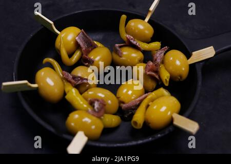 spanische Vorspeisen, Spieß mit eingelegtem Chili, Oliven und Sardellen, bekannt als Antipasti Stockfoto