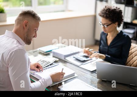Zwei Kollegen Berechnung der Steuer im Büro Stockfoto