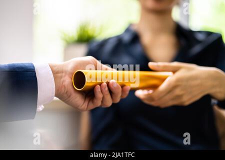 Nahaufnahme der Geschäftsmann Hand vorbei an der Goldenen Staffelstab an seinen Partner im Büro Stockfoto