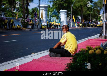 Bangkok, Thailand. 05.. Mai 2019. Ein Mann sitzt am Straßenrand, während er auf die königliche Prozession von König Maha Vajiralongkorn wartet. Auf den Straßen Bangkoks standen Menschen, um die Krönung des Königs Vajiralongkorn zu feiern, der nach dem Tod seines Vaters, König Bhumibol Adulyadej, mehr als zwei Jahre nach seiner Thronbesteigung in einer religiösen Zeremonie gekrönt wurde. (Foto von Eduardo Leal/SOPA Images/Sipa USA) Quelle: SIPA USA/Alamy Live News Stockfoto