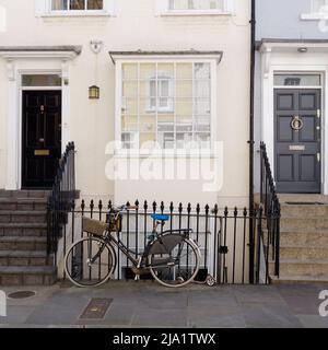 London, Greater London, England, Mai 14 2022: Fahrradfahren vor malerischen Anwesen in der Nähe der Kings Road im Chelsea-Gebiet. Stockfoto