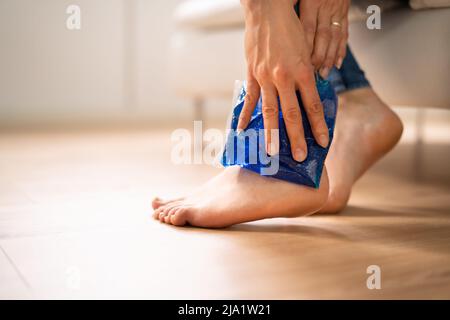 Nahaufnahme von einer Frau Hand Anwendung Ice Gel Pack auf Ihrem Knöchel Stockfoto