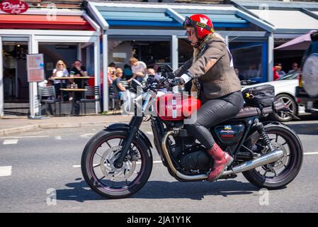 Motorradfahrerin, die an der berühmten Veranstaltung Gentleman's Ride Motorrad teilnimmt und einen Triumph Speed Twin fährt Stockfoto