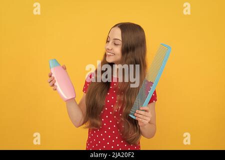 Happy Kid Kämmen lange Haare. Friseur. Mädchen hat wellige Frisur halten Haarbürste Stockfoto