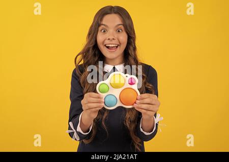 Stauned teen Mädchen spielen mit Pop it oder einfache Grübchen Silikon sensorische Fidget Spielzeug, einfache dimpl Stockfoto