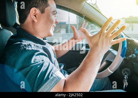 Ungeduldiges Schreien des Fahrers, Porträt eines wütenden Fahrers, der in seinem Auto schrie, gestresster Fahrer, der einen anderen Fahrer anschrie, Konzept eines ungeduldigen Fahrers Stockfoto