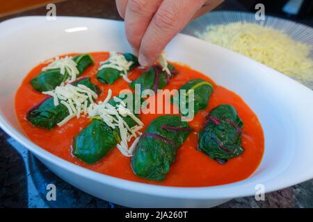 Schwäbische Küche, Bietigheimer Laubfrösche in Paprikasoße, Sauce, gefüllte Mangold Blätter in Paprikasoße werden mit Käse bestreut, geriebt Stockfoto