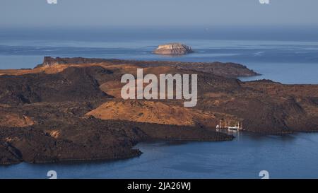 Morgenlicht, ruhiges Meer, kleiner Hafen, Boote, vulkanische Insel Palea Kameni, vulkanische Insel Nea Kameni, Caldera, Insel Santorini Stockfoto